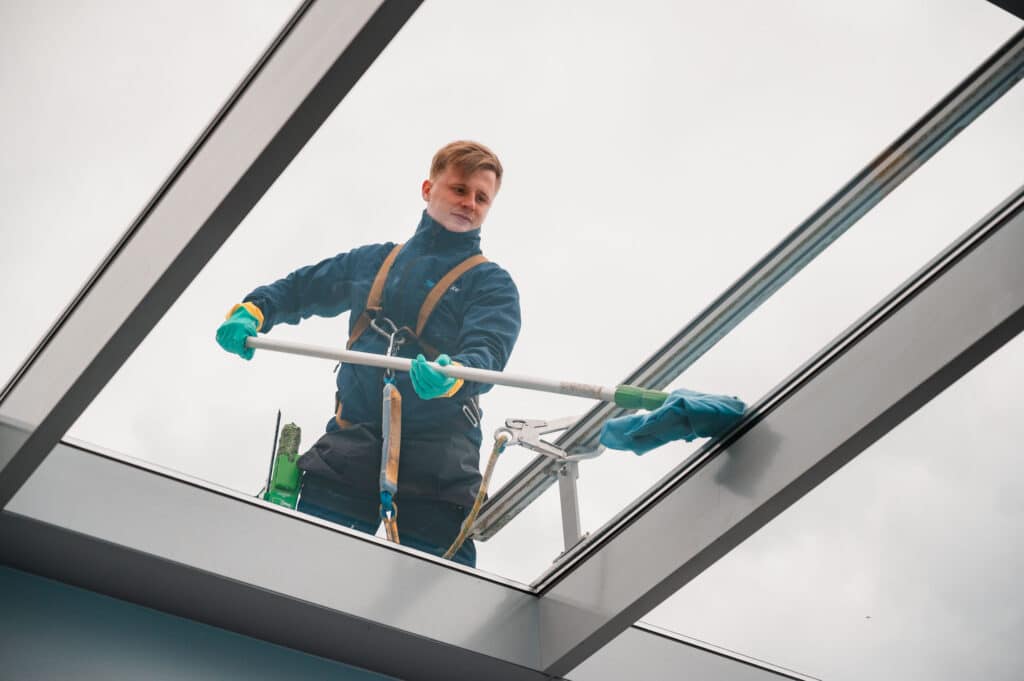 Mitarbeiter von Tidy Service reinigt ein Glasdach